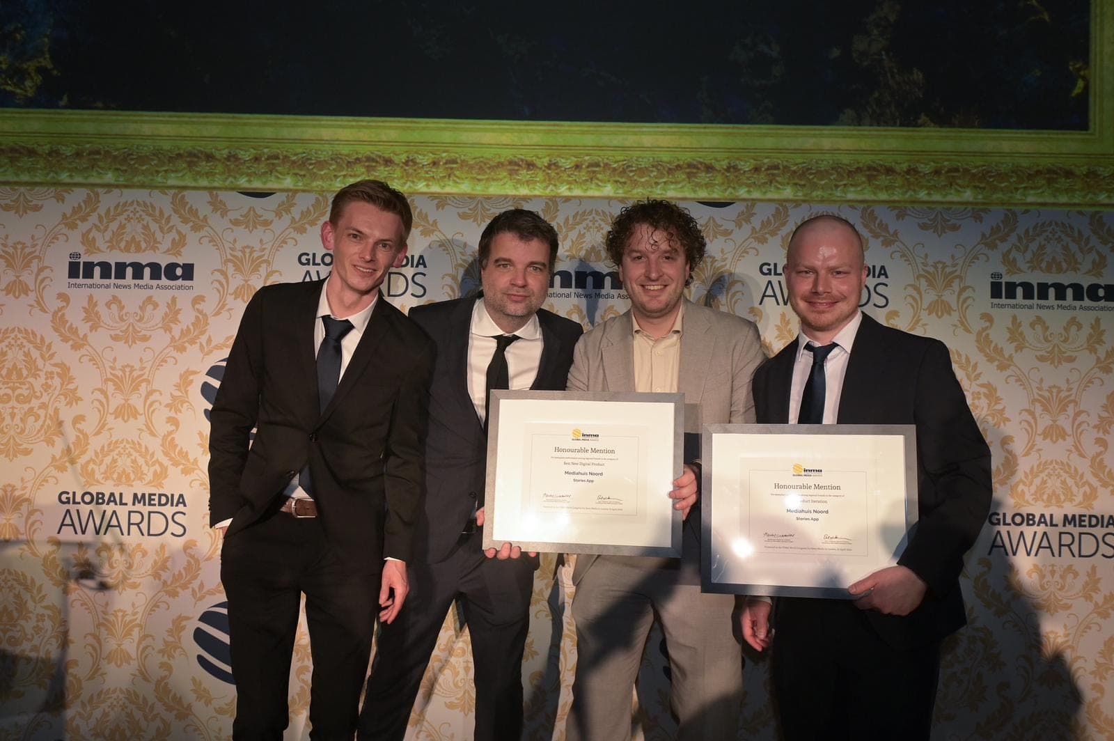 The app team in suits in front of the INMA Global Media Awards backdrop, holding two framed certificates. Sebastiaan is third from the left.